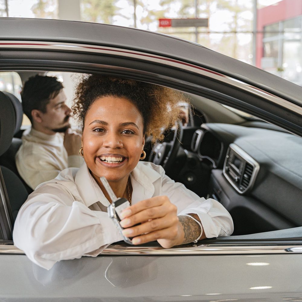 Driver holding car keys through the open window of her car